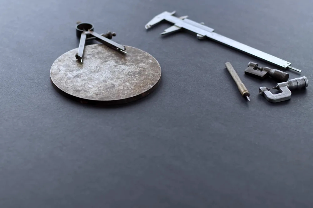 Precision measuring tools including callipers laid out on a black surface